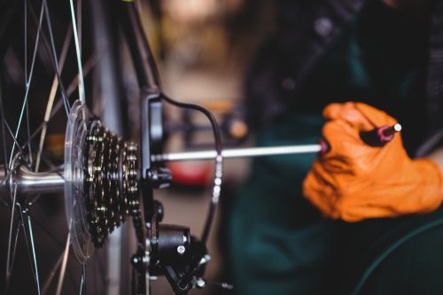 Close-up of mechanic repairing a bicycle in workshop